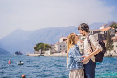 Aşık mutlu çift ve kadın turistler güneşli bir günde Eski Perast kasabasında renkli caddelerin tadını çıkarıyorlar. Karadağ 'a seyahat. Tarihi Perast kasabasının manzara manzarası