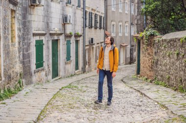 Ünlü Kotor Körfezi 'nde tarihi Risan kasabasının manzaralı manzaralı manzaralı erkek turist güzel güneşli bir günde mavi gökyüzü ve bulutlarla yaz mevsiminde Karadağ, güney Avrupa.