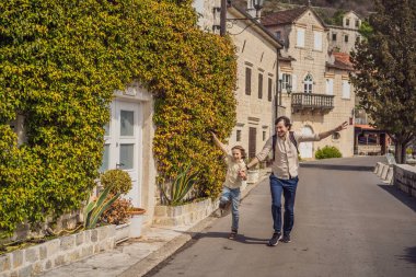Baba ve oğul turistler güneşli bir günde Karadağ 'ın Eski Perast kasabasında renkli caddelerin tadını çıkarıyorlar. Karadağ 'a seyahat. Ünlü Kotor Körfezi 'ndeki tarihi Perast kasabasının manzara manzarası.