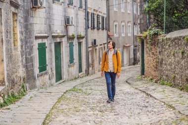 Ünlü Kotor Körfezi 'nde tarihi Risan kasabasının manzaralı manzaralı manzaralı erkek turist güzel güneşli bir günde mavi gökyüzü ve bulutlarla yaz mevsiminde Karadağ, güney Avrupa.