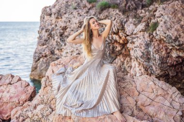 Kadın turist Karadağ 'da kayalıklara karşı. Karadağ 'ın Adriyatik Denizi kıyısındaki güzel yeşil Kraliyet Parkı Milocer' in panoramik yaz manzarası.