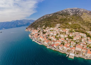 Ünlü Kotor Körfezi 'ndeki tarihi Perast kasabasının manzara manzarası. Çiçekler açan güzel güneşli bir günde mavi gökyüzü ve yazın bulutlar, Karadağ, güney Avrupa.