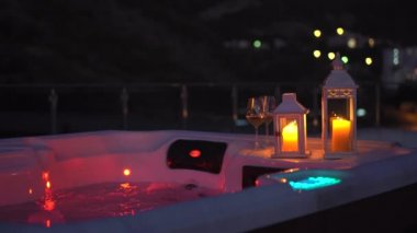 Gece sahnesi. Geceleri çatıda bir jakuzi ve yanında mumlar..