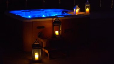 Gece sahnesi. Geceleri çatıda bir jakuzi ve yanında mumlar..