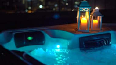 Gece sahnesi. Geceleri çatıda bir jakuzi ve yanında mumlar..