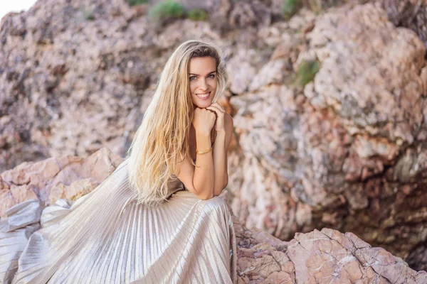 Kadın turist Karadağ 'da kayalıklara karşı. Karadağ 'ın Adriyatik Denizi kıyısındaki güzel yeşil Kraliyet Parkı Milocer' in panoramik yaz manzarası.