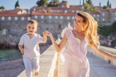 Anne ve oğul turistler güzel manzaralı St. Stephen adası, Budva Riviera, Budva, Karadağ 'da Sveti Stefan. Karadağ 'a Seyahat.
