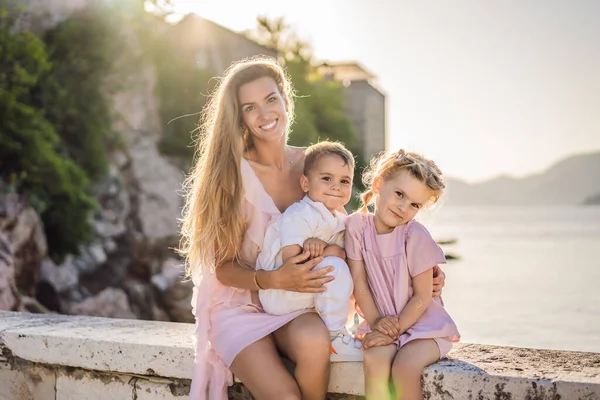 Anne ve iki çocuk turist güzel manzaralı St. Stephen adası, Budva Riviera, Budva, Karadağ 'daki Sveti Stefan' ın arka planında. Karadağ 'a Seyahat.