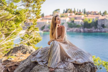 Karadağ 'ın Budva Riviera kentindeki St. Stephen adasının güzel manzaralı kadın turist Sveti Stefan. Karadağ 'a Seyahat.