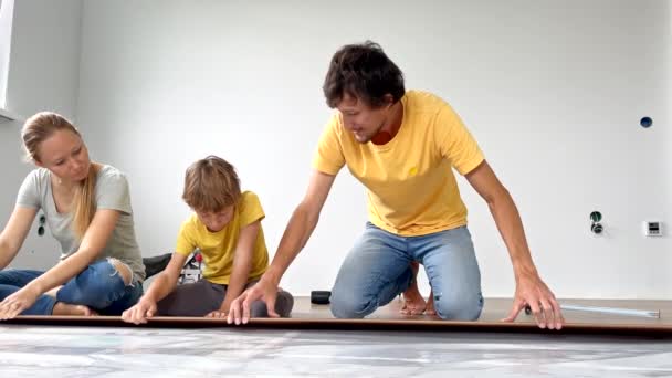 Uma Família Mãe Pai Filho Instalar Laminado Chão Seu Apartamento — Vídeo de Stock
