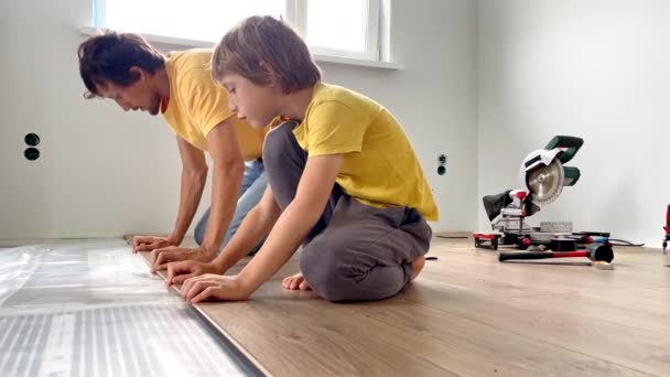 父亲和他的小儿子在他们公寓的地板上安装了层压板 Diy概念 慢动作视频 — 图库视频影像