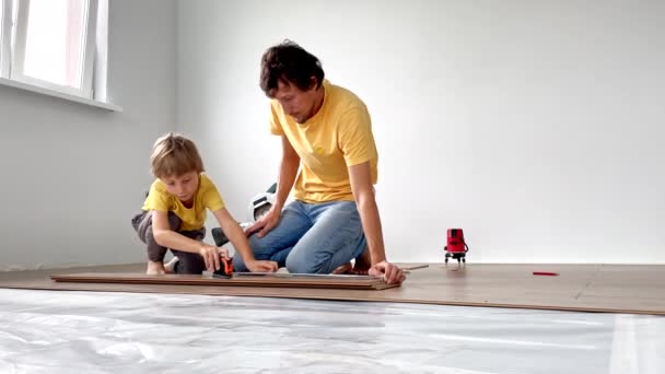 Father His Little Son Install Laminate Floor Apartment Diy Concept — Stock Video