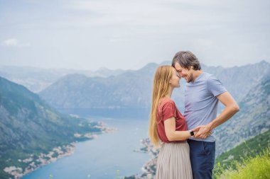 Erkek ve kadın turistler Kotor manzarasının keyfini çıkarıyorlar. Karadağ. Kotor Körfezi, Kotor Körfezi, Boka Kotorska ve eski şehrin duvarları. Karadağ 'a seyahat. Kotor 'un tahkimatları UNESCO' da