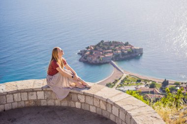 Karadağ 'ın Budva Riviera kentindeki St. Stephen adasının güzel manzaralı kadın turist Sveti Stefan. Karadağ 'a Seyahat.