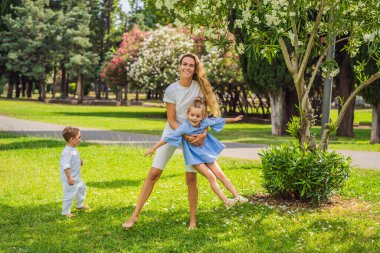 Parktaki çimlerin üzerinde mutlu bir aile, gülen yüzler, eğleniyorlar..