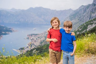 İki erkek arkadaş Kotor 'un manzarasının tadını çıkarıyor. Karadağ. Kotor Körfezi, Kotor Körfezi, Boka Kotorska ve eski şehrin duvarları. Karadağ 'a seyahat. Kotor 'un tahkimatları UNESCO Dünya Mirası' nda.