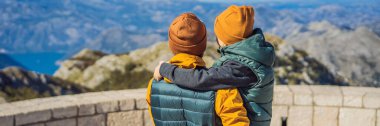 Banner, eski baba ve oğlu Karadağ 'daki ulusal park Lovcen' de dağ manzarası gezginleri. Karadağ 'a çocuk konseptiyle seyahat.
