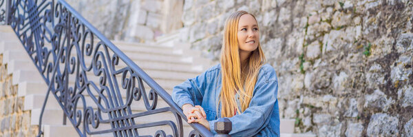 Young woman tourist in the old town of Budva. Travel to Montenegro concept. BANNER, LONG FORMAT