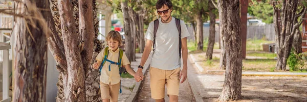 Dad and son tourists walks along the coast of Budva in Montenegro. BANNER, LONG FORMAT