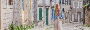 BANNER, LONG FORMAT Woman tourist on background of Scenic panorama view of the historic town of Risan at famous Bay of Kotor on a beautiful sunny day with blue sky and clouds in summer, Montenegro