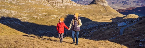 BANNER, LONG FORMAT Montenegro. Mom and son tourists in the background of Durmitor National Park. Saddle Pass. Alpine meadows. Mountain landscape. Travel around Montenegro concept.