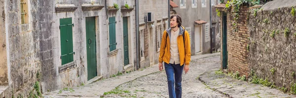 BANNER, BANNONG eski erkek turist arka planda tarihi Risan kasabasının manzaralı manzarası ünlü Kotor Körfezi 'nde güneşli güzel bir günde mavi gökyüzü ve bulutlu yaz mevsiminde Karadağ