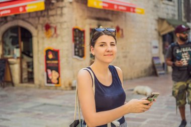 Karadağ 'ın eski Kotor kasabasında güneşli bir günde Renkli Sokak' ın tadını çıkaran kadın turist. Karadağ 'a Seyahat.