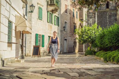 Karadağ 'ın eski Kotor kasabasında güneşli bir günde Renkli Sokak' ın tadını çıkaran kadın turist. Karadağ 'a Seyahat.