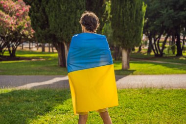 Adamın biri omuzlarına Ukrayna bayrağı asmış. Ukraynalı vatansever konsepti, Ukrayna 'yı desteklemek için miting.