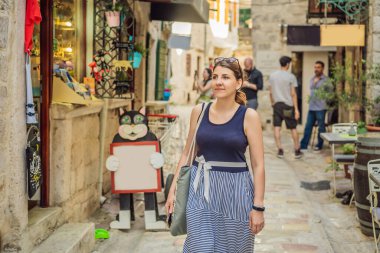 Karadağ 'ın eski Kotor kasabasında güneşli bir günde Renkli Sokak' ın tadını çıkaran kadın turist. Karadağ 'a Seyahat.