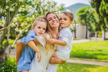 Parktaki çimlerin üzerinde mutlu bir aile, gülen yüzler, eğleniyorlar..