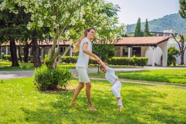 Genç ve güzel anne çocuğuyla dışarıda oynuyor..