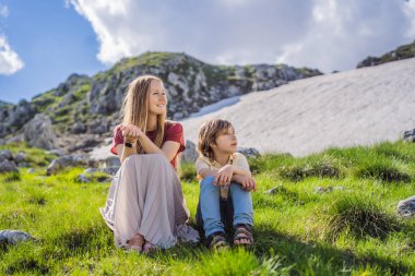 Family of tourists mom and son in Mountain lake landscape on Durmitor mountain in Montenegro beautiful Durmitor National park with lake glacier and reflecting mountain.