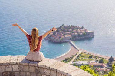 Karadağ 'ın Budva Riviera kentindeki St. Stephen adasının güzel manzaralı kadın turist Sveti Stefan. Karadağ 'a Seyahat.