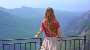A young woman observes beautiful canyon of the Cijevna river on a way to the Grlo Sokolovo, a famous canyon at the Montenegro-Albania border. Travel to Montenegro concept.