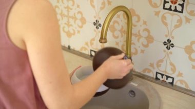 Genç bir kadın elektrikli aroma lambasını yıkıyor. Aromaterapi Konsepti. Elektronik Ultrasonik Temel Yağ Yayıcı ve Nemlendirici. Yakın çekim videosu.