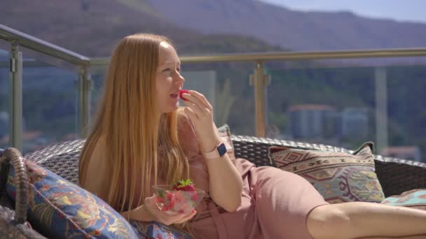 Młoda Kobieta Truskawki Leżące Kanapie Balkonie Górami Tle — Wideo stockowe