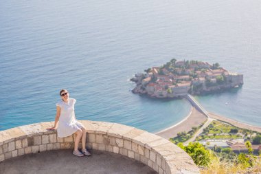 Karadağ 'ın Budva Riviera kentindeki St. Stephen adasının güzel manzaralı kadın turist Sveti Stefan. Karadağ 'a Seyahat.