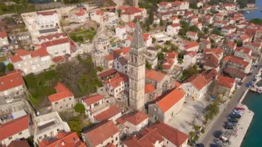 Hava videosu. Perast şehrinin manzarası. Şehrin merkezinde Saint Nikolas kilisesinin çan kulesi bulunmaktadır. Karadağ 'a Seyahat.