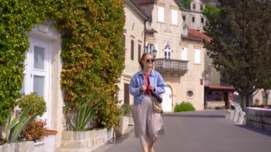 Boka-Kotorska körfezindeki güzel bir sahil kasabası olan Perast şehri kıyılarında genç bir kadın yürüyor..