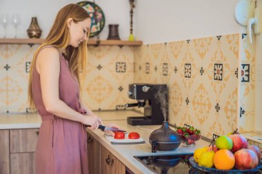 Kadın aroma dağıtıcısının yanında yemek hazırlıyor. Aşçı mutfakta olgun kırmızı biber keser. Konuklar için taze, olgun, dolmalık biber salatası yapıyorum. Yaz taze sebze salatası.