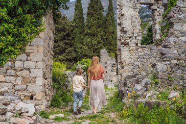 Anne ve oğul turistler Karadağ 'ın eski Bar kasabasından geçiyorlar. Dağlarda mutlu turist yürüyüşleri. Baro, Karadağ, Balkanlar 'ın banliyöleri. Güzel doğa ve manzara.