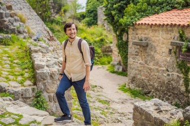 Erkek turist Karadağ 'ın eski Bar kasabasında yürüyor. Dağlarda mutlu turist yürüyüşleri. Baro, Karadağ, Balkanlar 'ın banliyöleri. Güzel doğa ve manzara.