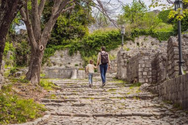 Baba ve oğul turistler Karadağ 'ın eski Bar kasabasından geçiyorlar. Dağlarda mutlu turist yürüyüşleri. Baro, Karadağ, Balkanlar 'ın banliyöleri. Güzel doğa ve manzara.