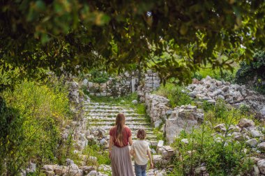 Anne ve oğul turistler Karadağ 'ın eski Bar kasabasından geçiyorlar. Dağlarda mutlu turist yürüyüşleri. Baro, Karadağ, Balkanlar 'ın banliyöleri. Güzel doğa ve manzara.