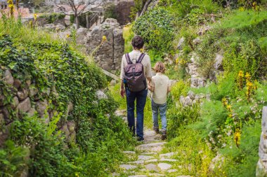 Baba ve oğul turistler Karadağ 'ın eski Bar kasabasından geçiyorlar. Dağlarda mutlu turist yürüyüşleri. Baro, Karadağ, Balkanlar 'ın banliyöleri. Güzel doğa ve manzara.