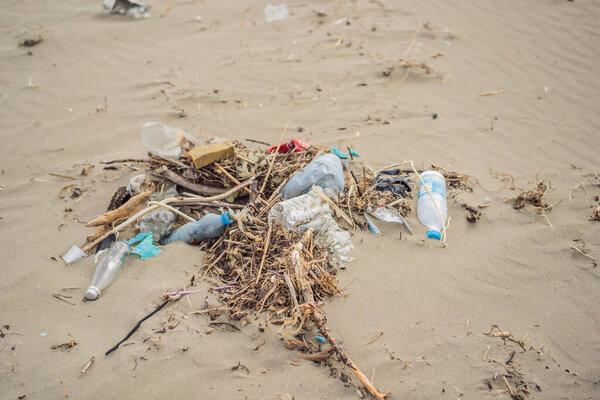 Spilled garbage on the beach. Empty used dirty plastic bottles. Environmental pollution. Ecological problem.