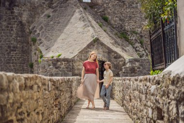 Anne ve oğul turistler Herceg Novi 'nin eski kasabasında. Herceg Novi 'nin tarihi ve turistik merkezi. Karadağ.
