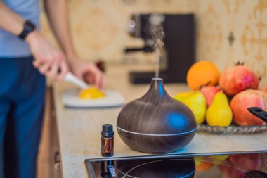 Bir adam aroma yayıcısının yanında yemek hazırlar. Aşçı mutfakta olgun kırmızı biber keser. Konuklar için taze, olgun, dolmalık biber salatası yapıyorum. Yaz taze sebze salatası.