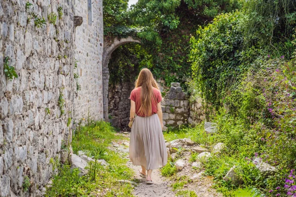 Woman tourist walks through the old town of Bar in Montenegro. Happy tourist walks in the mountains. Suburbs of the city of Bar, Montenegro, Balkans. Beautiful nature and landscape.